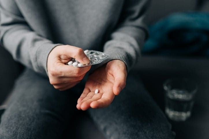 Prescription claiming. Photo of a man taking a pill from its packaging.