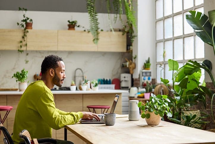 Man sitting at a workspace on a laptop